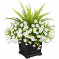 Künstliche Blumenarrangement mit weißen Blüten und Farn in schwarzem Topf